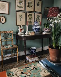 a living room with blue walls and pictures on the wall, including a potted plant