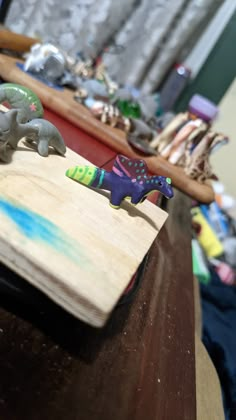 two small toy elephants sitting on top of a wooden table next to other toys and items