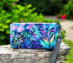 Floral wristlet purse, this zippered pouch would make a fun addition to any handcrafted purse collection or give as a unique gift that is ready to ship! On this floral bag custom print cotton lycra fabric with bold colors and a combination of flowers, plants and leaves is combined with a mottled black/blue for the liner and a black vinyl wrist strap. On the inside there is a slip pocket on each side made with the same floral fabric.  FABRIC IS BRIGHTER THAN THE PICTURES! My camera wasn't picking Multicolor Zipper Pouch Wristlet Clutch, Multicolor Wristlet Clutch With Zipper, Handheld Wristlet With Zipper Pouch For Gift, Handheld Wristlet With Zipper Pouch As Gift, Multicolor Wristlet With Zipper Closure As Gift, Multicolor Zipper Pouch Wristlet For Gift, Multicolor Zipper Pouch Wristlet As Gift, Multicolor Zipper Pouch Wristlet, Multicolor Wristlet With Zipper Pouch As Gift