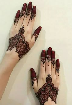 two hands with henna tattoos on them