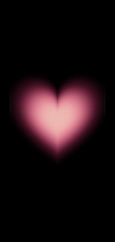 a blurry image of a pink heart in the middle of black background with space for text