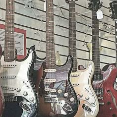 guitars are lined up on display in a store