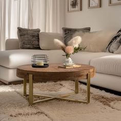 a living room with white couches and rugs on the floor in front of a window