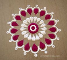 a red and white circular design made out of paper on top of a wooden table