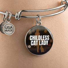 Get our Childless Cat Lady Bracelet today and be amazed by its quality and style! Made with durable surgical steel and the option for 18k gold finish, this jewelry item is the ultimate keepsake for yourself or your loved ones. Plus, we offer a 100% Happiness Guarantee - if for any reason you're not completely satisfied, just let us know and we'll make it right. Your satisfaction is our top priority. Product Dimensions➜ Luxury Bangle: 7-9" (18-22.75cm). This bangle features a stretchable design that allows it to expand as you slide it onto your wrist, then it effortlessly returns to its original shape.➜ Circle Pendant: 23.5mm x 23.5mm. Stainless Steel Friendship Bangle, Hypoallergenic Adjustable Surgical Steel Jewelry, Adjustable Hypoallergenic Surgical Steel Jewelry, Hypoallergenic Stainless Steel Jewelry, Nickel Free Stainless Steel Jewelry For Friendship, Nickel-free Round Surgical Steel Jewelry, Hypoallergenic Round Surgical Steel Jewelry, Hypoallergenic Surgical Steel Round Jewelry, Nickel-free Adjustable Surgical Steel Jewelry