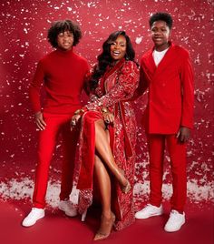 three people in red outfits posing for a photo