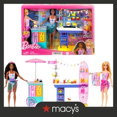 two barbie dolls are in front of a toy ice cream stand and table with surfboard