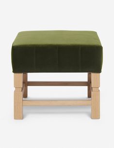 a green foot stool with wooden legs