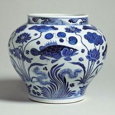 a blue and white vase with fish on it