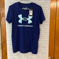 a blue under armour t - shirt hanging on a door