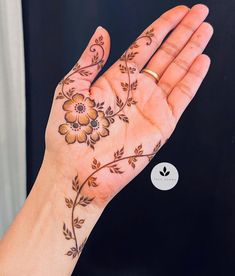 a woman's hand with a flower tattoo on it