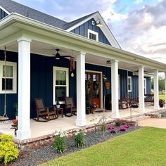 a blue house with white pillars and porches