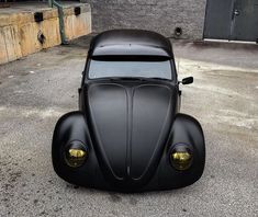 an old black car is parked on the street