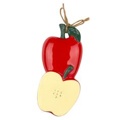 an apple shaped ceramic ornament hanging from a string