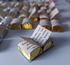 several different types of candy are lined up on a table with one folded paper in the middle