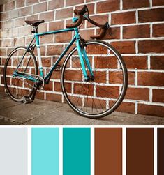 a blue bike leaning against a brick wall with color swatches in the foreground