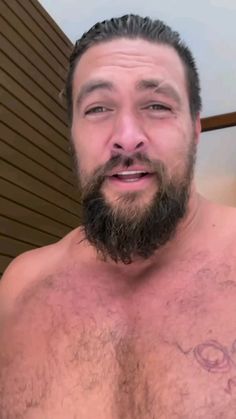 a man with a beard and no shirt is taking a selfie