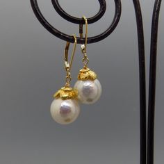 These lovely Edison pearls are near perfect with amazing glow. The pearls are capped with gold plate sterling flower caps. The ear wires are gold filled lever backs. Heirloom jewelry that is timeless and elegant. material:     Edison freshwater pearl, gold plate sterling flower cap and ear wires. dims:           1 and 1/4 inches long. pearl size:   10 mm. pearl type:  Edison freshwater. Classic Handmade Yellow Gold Pearl Earrings, Handmade Classic Yellow Gold Pearl Earrings, Gold Pearl Lever Back Earrings For Formal Events, Gold Akoya Pearl Earrings With Ear Wire, Gold Round Pearl Earrings With French Hook, Heirloom Jewelry, Edison Pearls, Freshwater Pearl Earrings, Heirlooms Jewelry