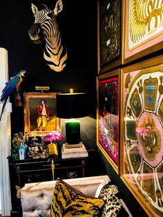 a living room filled with furniture and pictures on the wall next to a zebra head