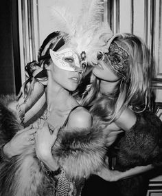 two beautiful women in masks posing for the camera