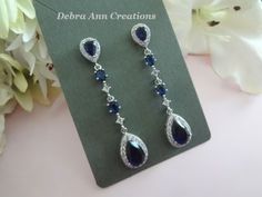 Same Style Earrings-Shorter Length: https://www.etsy.com/listing/1302867248 Similar Designs with Clear and Sapphire Cubic Zirconia: https://www.etsy.com/listing/1337182650 https://www.etsy.com/listing/1414245091 Matching Bracelet: https://www.etsy.com/listing/1353304140 https://www.etsy.com/listing/1456206829 Matching Hair Pin: https://www.etsy.com/listing/880678156 Item #BRER4076 These Handmade, Original Design crystal earrings are comprised of Sapphire Cubic Zirconia Teardrop framed with round Blue Drop Bridal Earrings, Blue Teardrop Chandelier Earrings For Anniversary, Blue Drop Bridal Earrings For Party, Blue Dangle Bridal Earrings For Formal Occasions, Formal Blue Dangle Bridal Earrings, Elegant Blue Drop Chandelier Earrings, Blue Drop Bridal Earrings For Wedding, Blue Teardrop Wedding Earrings, Blue Teardrop Earrings For Anniversary