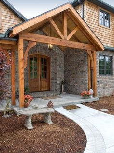 the front entrance to a home with a stone walkway leading up to it and a bench on the side