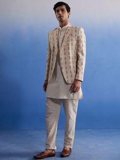 SHVAAS By VASTRAMAY Men's Cream Leaf Printed Blazer With Kurta Pyjama Set Elevate your ethnic wardrobe with this sophisticated cream leaf printed blazer paired with a classic kurta pyjama set. Perfect for weddings, festive occasions, or formal gatherings, this ensemble seamlessly blends tradition with modern style. Features Leaf printed cream blazer Classic kurta pyjama set Elegant and sophisticated design Perfect for weddings and festive occasions Combines tradition with modern style Specificat Blazer On Kurta For Men, Traditional Tailored Kurta For Eid, Traditional Tailored Sets For Festive Season, Festive Tailored Traditional Sets, Traditional Cotton Groom's Attire Set, Traditional Cotton Groom's Set, Cotton Nehru Jacket For Eid, Cotton Semi-formal Festive Sets, Festive Cotton Semi-formal Sets