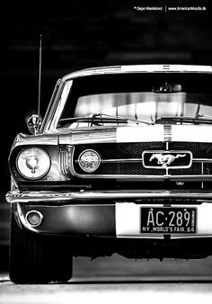 the front end of an old mustang car in black and white with stripes on it