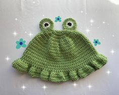 a green crocheted hat with two eyes on it