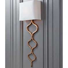 a wall mounted lamp on the side of a gray door with a white lampshade