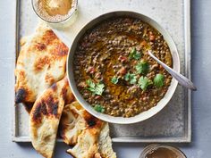 a bowl of soup and pita bread on a tray