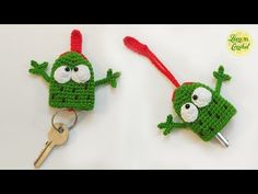 two crocheted key fobs with eyes and arms, one holding a key chain