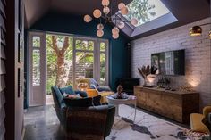 a living room filled with furniture and a skylight above the couches in front of it