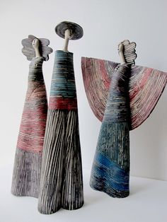 two ceramic sculptures made to look like they are holding umbrellas