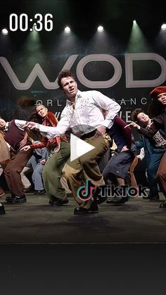 a group of people dancing on stage in front of a sign that says wood international