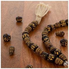 some beads are laying on a wooden table