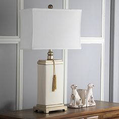 An elegant box shape and white shade define this Safavieh table lamp. In cream/white. Tassel accent adds a unique look. Three-way switch which allows you to adjust the brightness. 29 1/2H x 16 1/2W x 9D Requires one 100-watt CFL bulb (not included) Shade: cotton Base: ceramic Assembly required Model no. LIT4000A Size: Furniture. Color: Brown. Gender: unisex. Age Group: adult. Tassel Lamp, Cream Table Lamps, White Tassel, Table Lamp Sets, White Table Lamp, White Table, Linen Shades, Home Office Desks, Lighting Collections