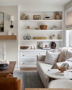 a living room filled with furniture and lots of shelves on the wall above it's fireplace