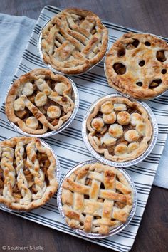 six pies sitting on top of a blue and white towel next to each other