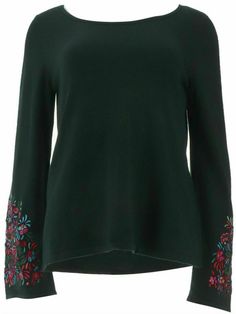 a green top with floral embroidered sleeves