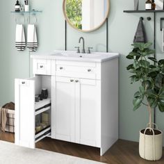 a white bathroom with green walls and wooden floors