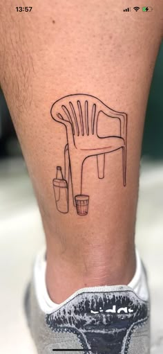 a man's leg with a chair tattoo on it