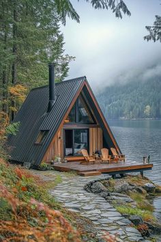 a small cabin sits on the shore of a lake