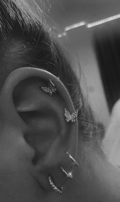 a close up of a person's ear with three piercings