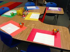 a classroom with several desks and chairs covered in colorful sheets of paper on top of them