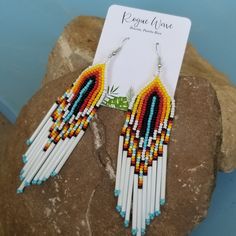 Bright seed bead earrings with sunrise pattern. They measure approximately 4.5 inches from drop. Very light and comfortable, featuring long premium glass seed beads.  Handmade by Roguewave in Puerto Rico. Presented on custom palm earring card so it is gift ready for that special person, of course that includes you too! Gracias por su visita! Free and fast shipping via USPS! Handmade White Heishi Beads Earrings, Adjustable Southwestern Beaded Earrings For Beach, Southwestern Style Beach Jewelry With Dangling Beads, White Southwestern Beaded Earrings For Festivals, Southwestern White Beaded Earrings For Festival, White Southwestern Style Beaded Earrings For Festival, White Teardrop Beaded Earrings For Beach, Handmade Southwestern Beaded Earrings For Beach, Southwestern Round Beads Earrings For Beach