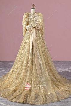 gold stiff glitter bubble sleeve formal gown with a bow Luxury Gold Gown For Prom Season, Luxury Long Sleeve Gold Gown, Luxury Gold Gown With Long Sleeves, Gold Long-sleeve Evening Dress For Gala, Gold Long Sleeve Gala Evening Dress, Gold Long Sleeve Evening Dress For Formal Occasions, Gold Long Sleeve Gala Dresses, Gold Long Sleeve Dress For Gala, Luxury Gold Sequin Gown