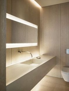 a bathroom with a toilet, sink and shelves on the wall next to each other