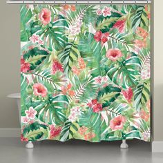 a shower curtain with tropical leaves and flowers on the outside, in front of a bathtub