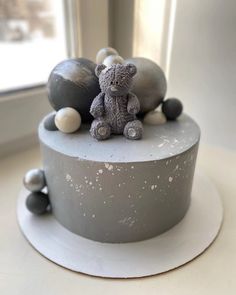 there is a small cake decorated with balls and a teddy bear